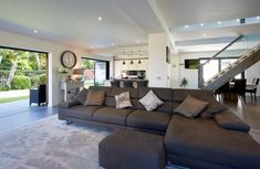 a living room filled with lots of furniture and a large open floor plan in front of a sliding glass door