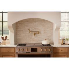 a stove top oven sitting inside of a kitchen next to wooden cabinets and counter tops