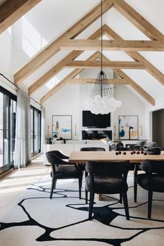 a dining room table with chairs and a chandelier hanging from it's ceiling