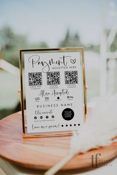 a wooden table topped with a sign and a white piece of paper on top of it