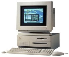 an old computer sitting on top of a desk next to a keyboard and mouse,