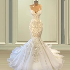 a white wedding dress on a mannequin in front of a wall and floor