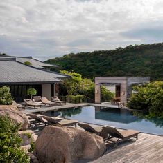 an outdoor swimming pool with chaise lounges next to it