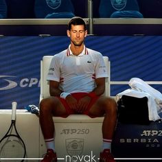 a male tennis player is sitting on the bench