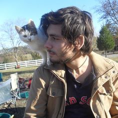 a man with a cat on his shoulders