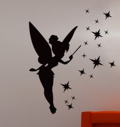 a wall decal with a fairy holding a wand and stars in the sky above it