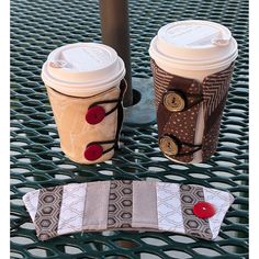 Two coffees from a restaurant in quilted holders with one shown in front. They are attached with buttons and elastic. Shown in multiple sizes. Cup Cozies Fabric, Sleeve Sewing Pattern, Drink Cozies, Cottage Quilt, Beginner Sewing Patterns, Cat Cuddle, Beginner Sewing, Cup Sleeve, Paper Sewing Patterns