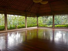 an empty room with wooden floors and large windows overlooking the jungles in costa rica, costa rica