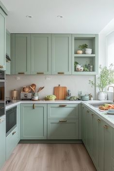 a kitchen with green cabinets and wooden floors