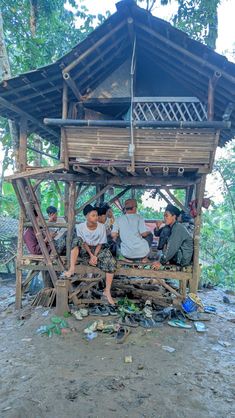 some people are sitting on a wooden structure