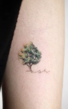 a small tree tattoo on the right side of the thigh, it is green and yellow