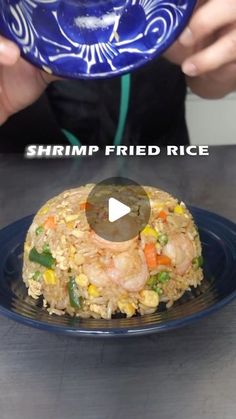 a person holding a plate with shrimp fried rice on it and the words shrimp fried rice