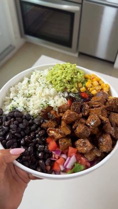 a person holding a bowl filled with meat and beans