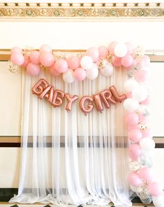 a baby girl balloon arch with pink and white balloons