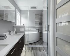 a bathroom with a tub, sink and large mirror on the wall next to it