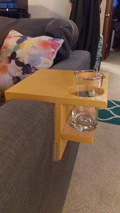 a table with a glass on it in front of a couch