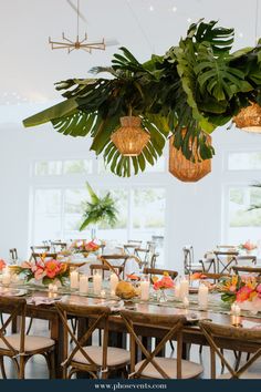 a dining room with tables and chairs covered in greenery, lit candles and flowers