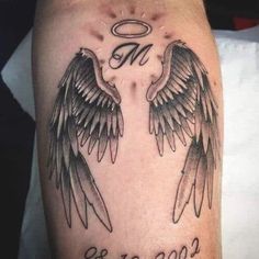 two black and white wings with an angel in the middle on a man's leg