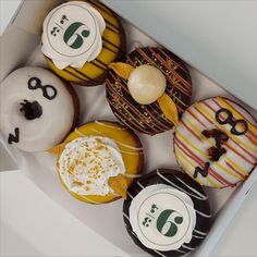 a box filled with lots of different flavored donuts on top of each other