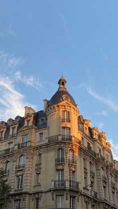 an old building with many windows and balconies on the top, against a blue sky