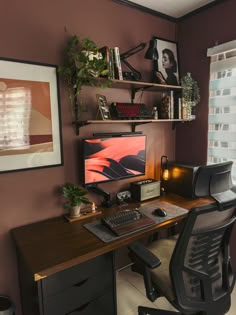 a desk with a computer on it in front of a window and some shelves filled with plants