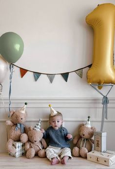 a baby is sitting on the floor surrounded by teddy bears and balloons in front of a number one sign