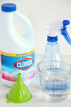 a bottle of clorox and a measuring cup filled with liquid