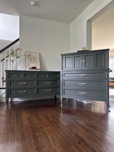 two gray dressers sitting next to each other on top of a hard wood floor