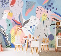 a colorful wall mural in a child's room with wooden chairs and toys on the floor