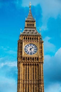 the big ben clock tower towering over the city of london on a sunny day with blue skies