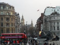 a busy city street with people walking and busses