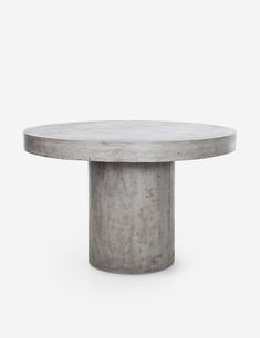 a round concrete table with a white marble top on an isolated surface, viewed from the front