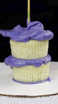 a cupcake with purple frosting and a single candle sticking out of it