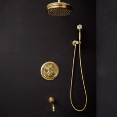 a gold shower head and hand shower in a black bathroom