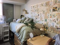 a woman sitting in front of a bed with lots of papers on the wall behind her