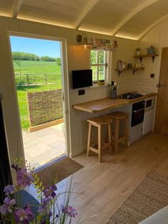 a kitchen with an open door leading to a patio area that has a table and stools in it