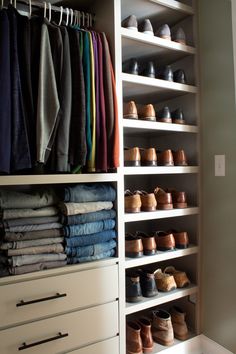 an organized closet with shoes, pants and blankets on the bottom shelf in front of it