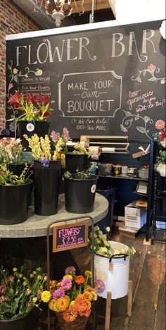 flowers are on display in front of a chalkboard sign that says, flower bar make your bouquet