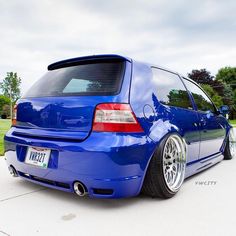 the back end of a blue car parked in a driveway