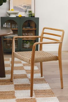 a wooden chair sitting on top of a rug next to a table