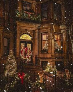 a house with christmas lights and wreaths on the front door