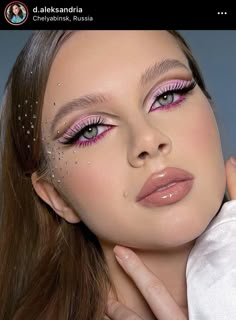 a woman with long hair and pink eyeshades is posing for the camera, her hand on her shoulder