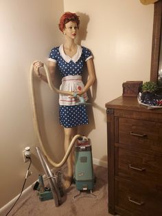 a mannequin is standing next to a vacuum