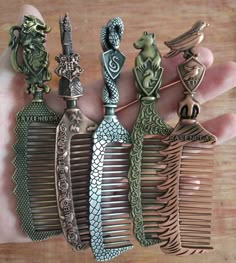 a person is holding several different types of hair combs in their hand, some with designs on them