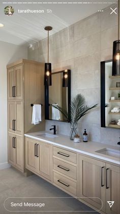 a large bathroom with two sinks and mirrors on the wall next to it's cabinets