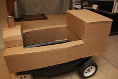 a cardboard boat sitting on top of a cart