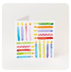 a card with watercolor candles on it and the words happy birthday written in different colors