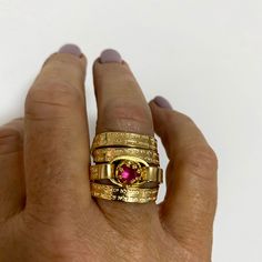 "This captivating, multiband, gold-filled ring features a stunning pink ruby and a beautiful Hebrew engraving of the Jewish Psalm Woman of Valor (Eshet Chayil.) With the ruby representing passion and the psalm a romantic verse from Husband to wife on Sabbath eve, this piece makes for a meaningful anniversary gift, engagement, or promise ring. The psalm is also fittingly an acrostic - every first letter in verse creates the entire Hebrew alphabet from the letter 'Aleph' to 'Tav', representing a c Gold Oval Pink Sapphire Rings, Gift Yellow Gold Stackable Rings With Wide Band, Yellow Gold Wide Band Stackable Rings For Gift, Gold Pink Sapphire Ring For Wedding, Wedding Gold Pink Sapphire Ring, Gold Ruby Ring Stamped 14k, Gold Rings With Pink Sapphire In Fine Jewelry Style, Gold Rings With Pink Sapphire Fine Jewelry, Gold Oval Stackable Birthstone Ring