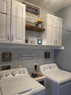 a white washer and dryer sitting in a room next to some cupboards