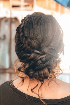 the back of a woman's head with braids in her hair